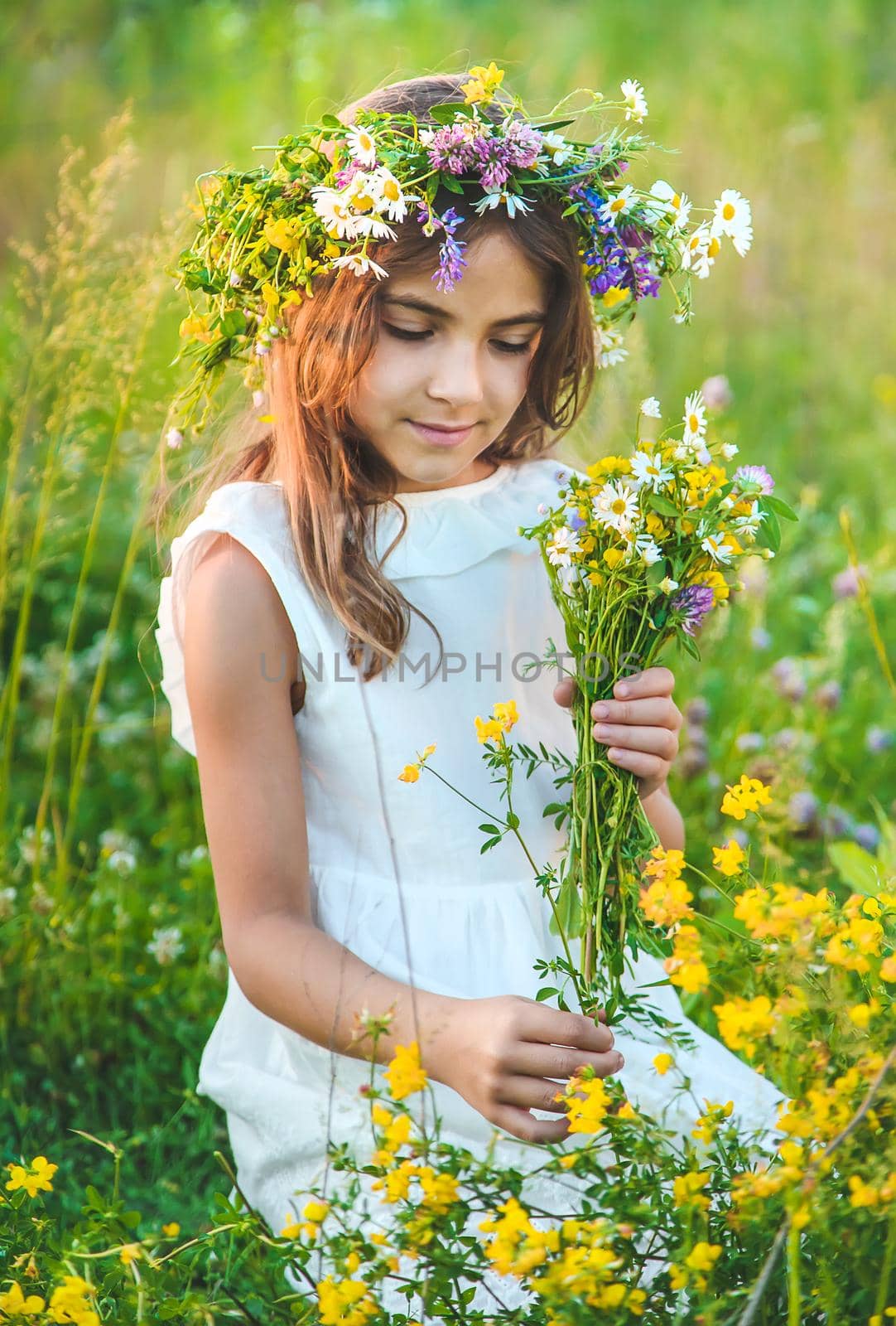 Child girl with wildflowers in summer. Selective focus. Nature.