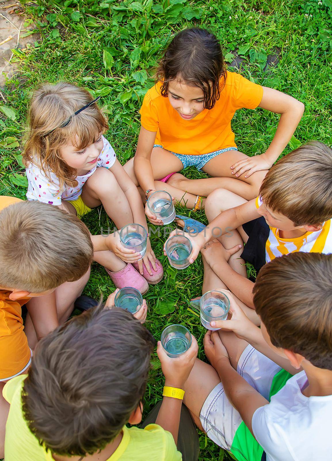 Children drink water outside together. Selective focus. Kids.