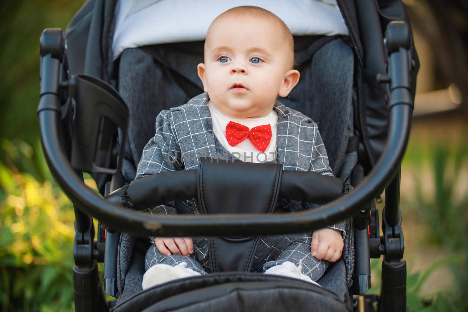 little boy sitting in a stroller by zokov