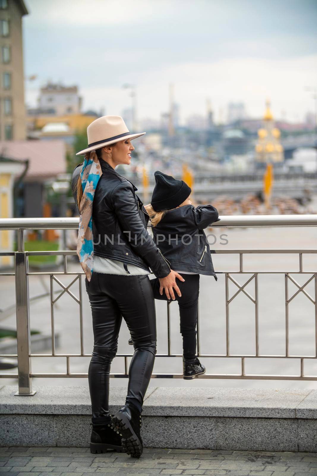 stylish mom and daughter walk the city