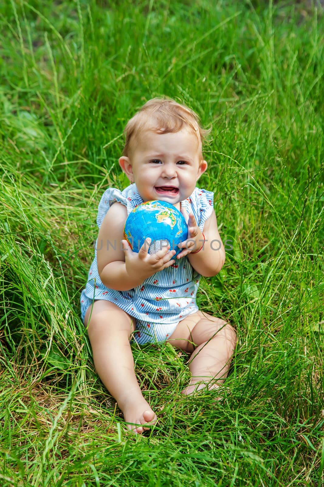 The child holds the globe in his hands. Selective focus. Nature.