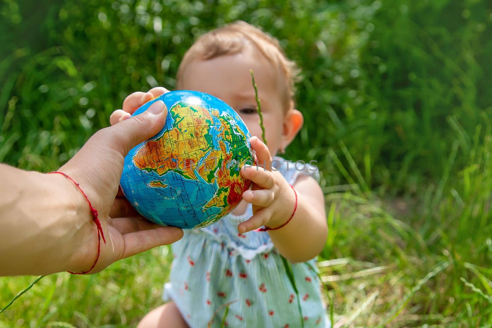 The child holds the globe in his hands. Selective focus. Nature.