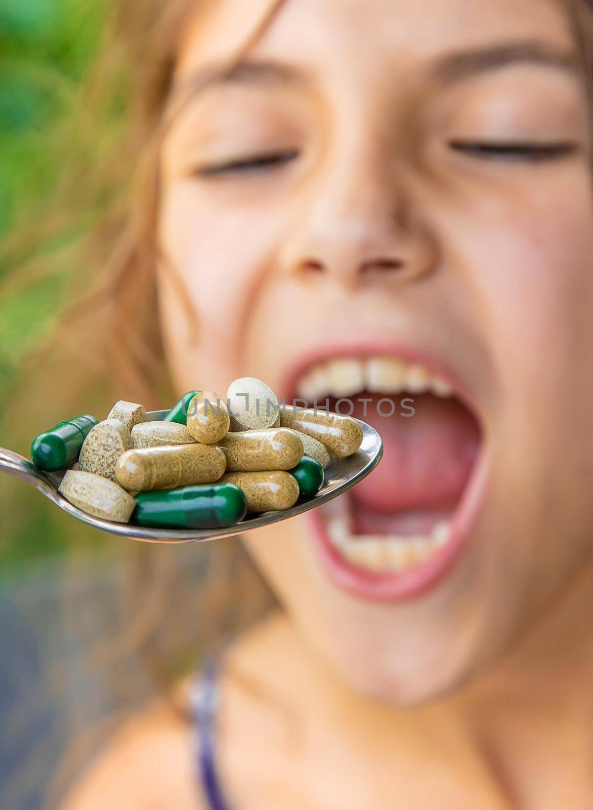 A spoonful of supplements and vitamins for a child. Selective focus. Kid.