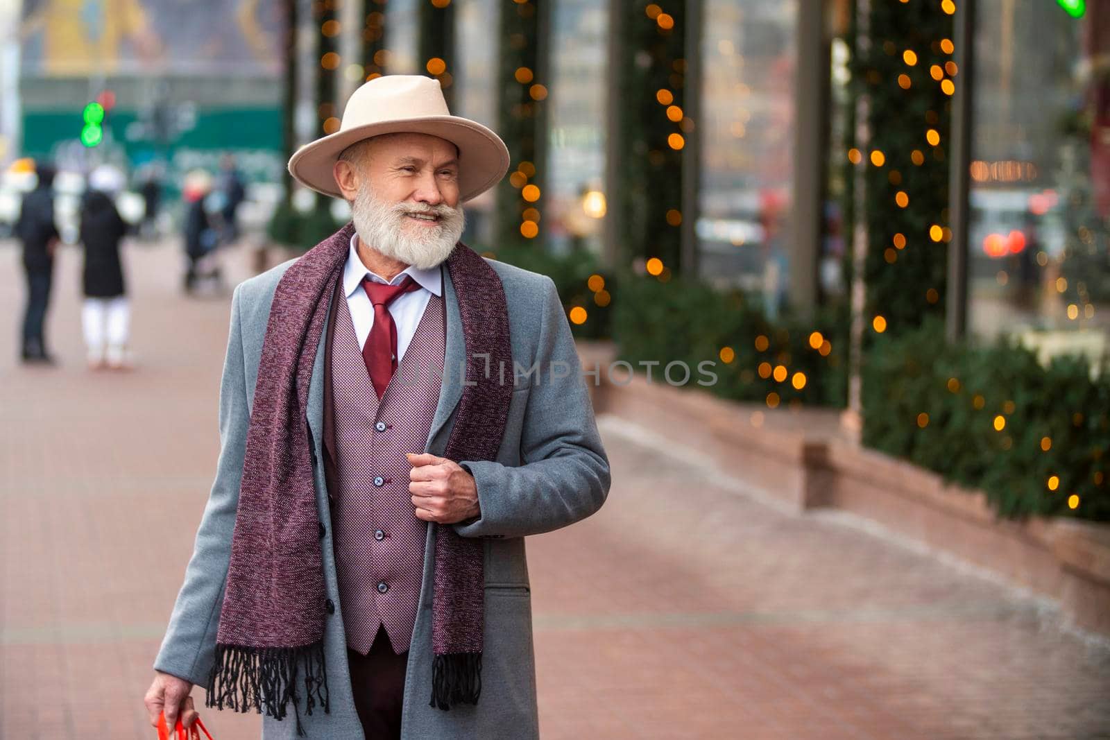 bearded grandfather with a handbag walks on the street