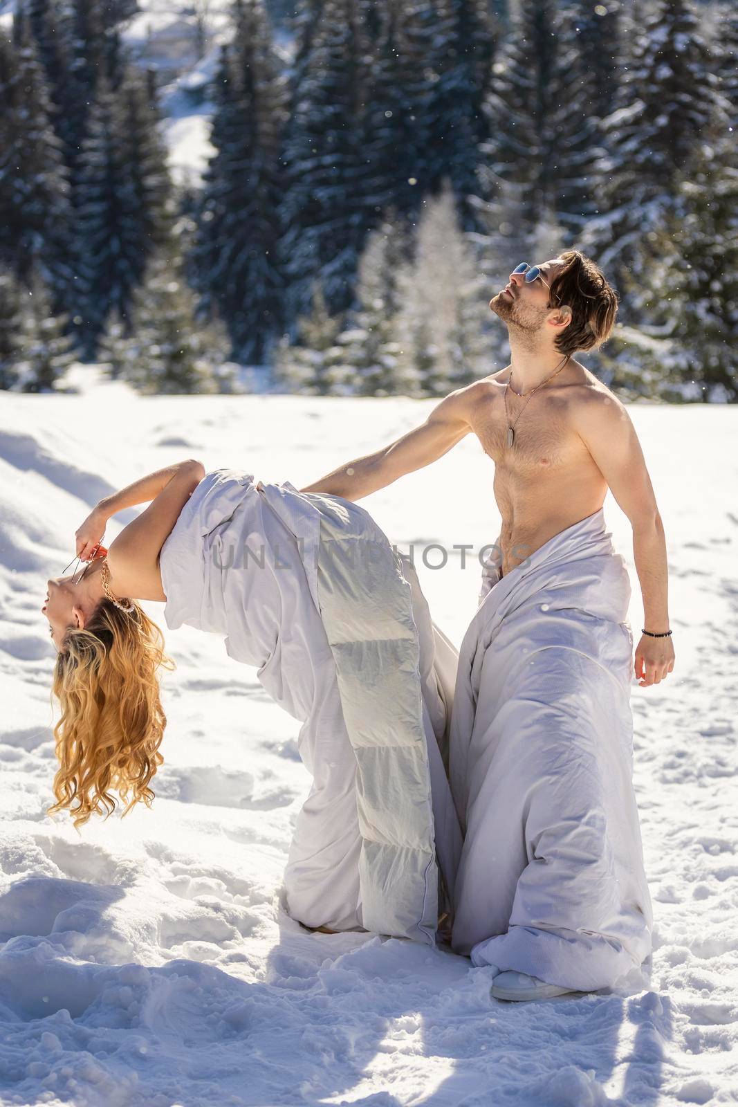 couple in blankets in winter against the background of mountains