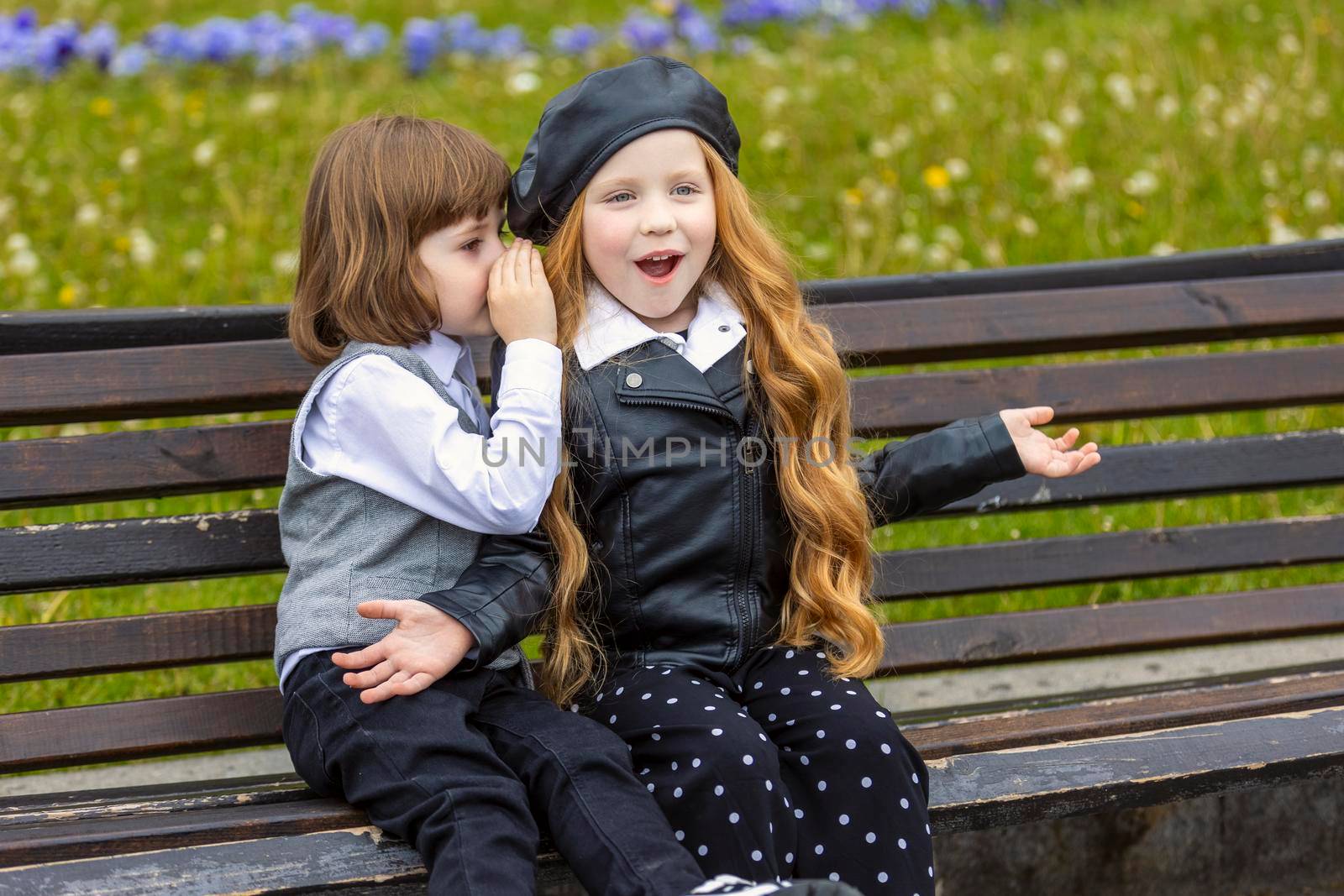 children sit on a bench in the city and talk