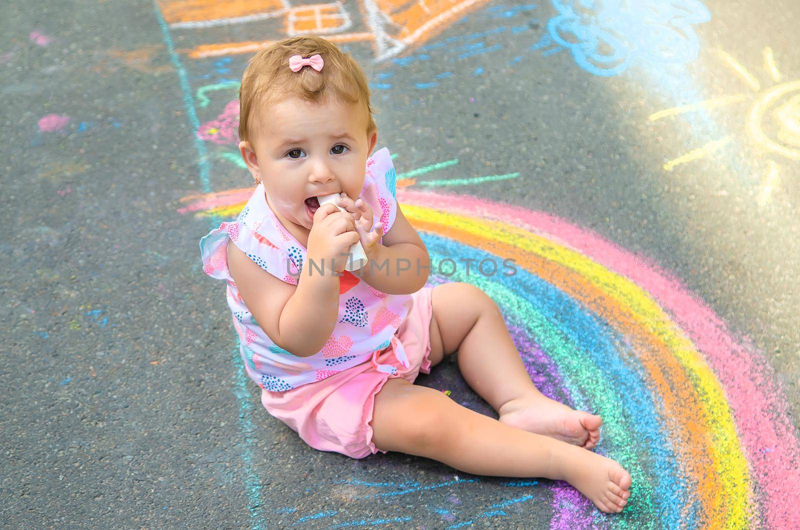 Baby eats chalk for drawing. Selective focus. Kids.