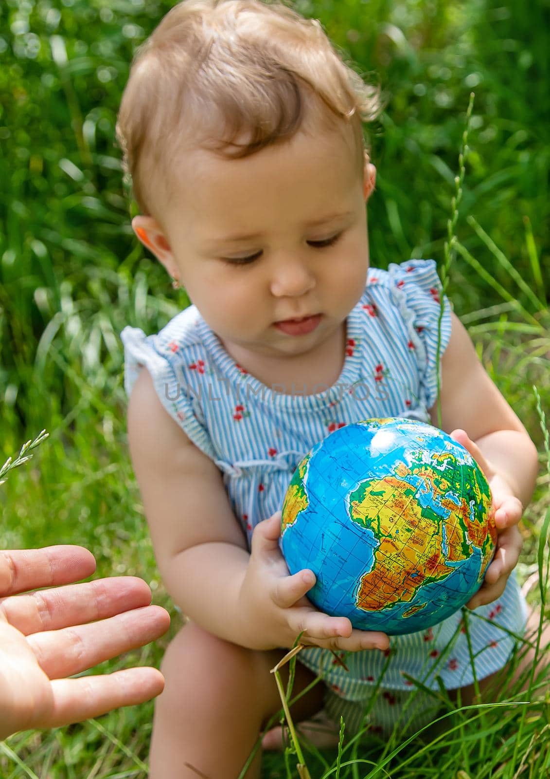 The child holds the globe in his hands. Selective focus. Nature.