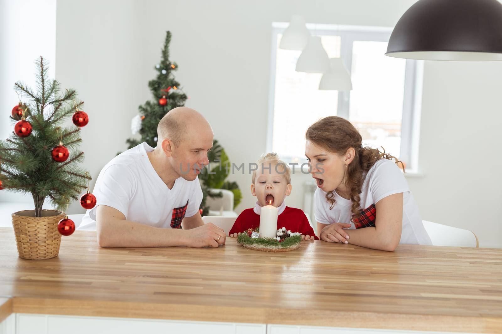 Baby child with hearing aid and cochlear implant having fun with parents in christmas room. Deaf , diversity and health concept by Satura86