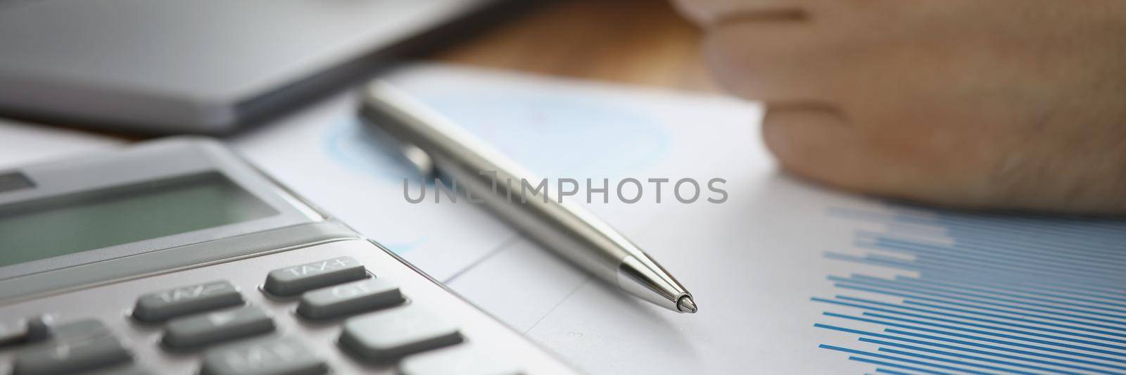 Close-up of person typing on laptop and calculating numbers in office. Businessman using computer to compose report. Business, statistics, success concept