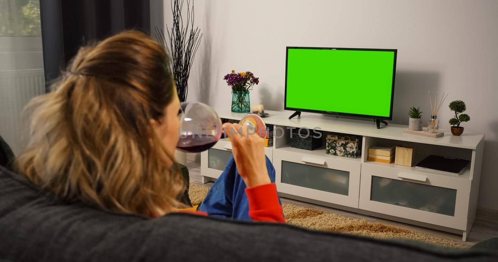 Woman watching Tv Green Chroma Key Screen and Drink wine. by RecCameraStock