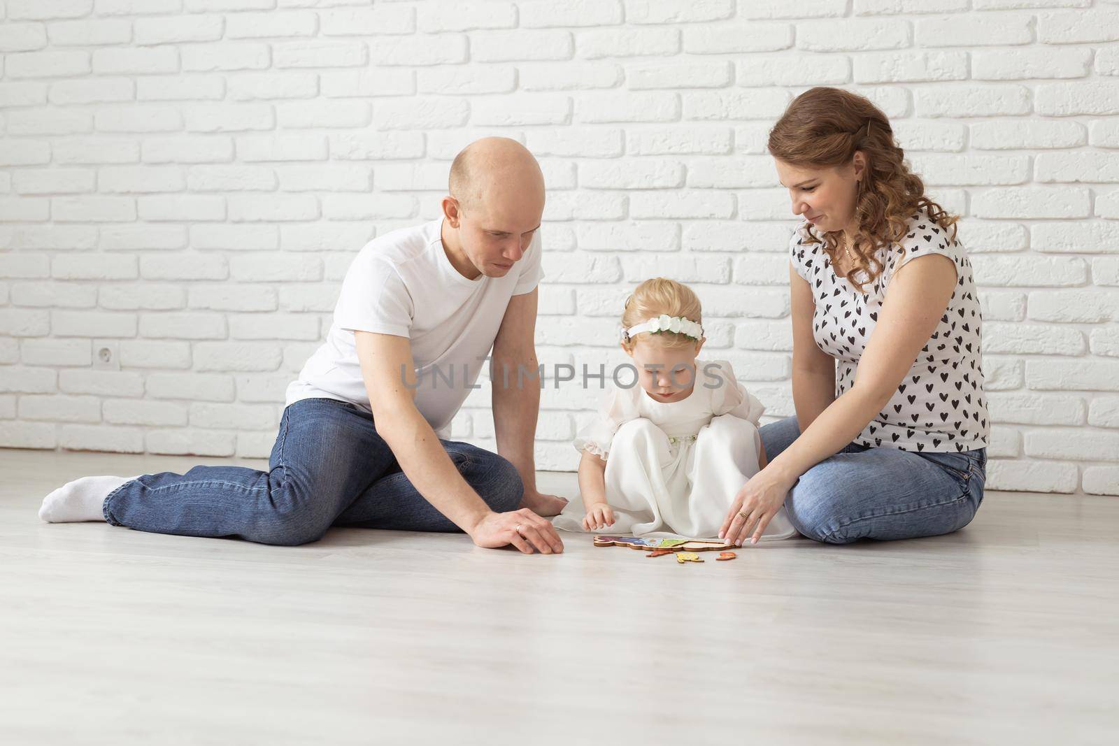 Baby child with hearing aids and cochlear implants plays with parents on floor. Deaf and rehabilitation and diversity concept by Satura86