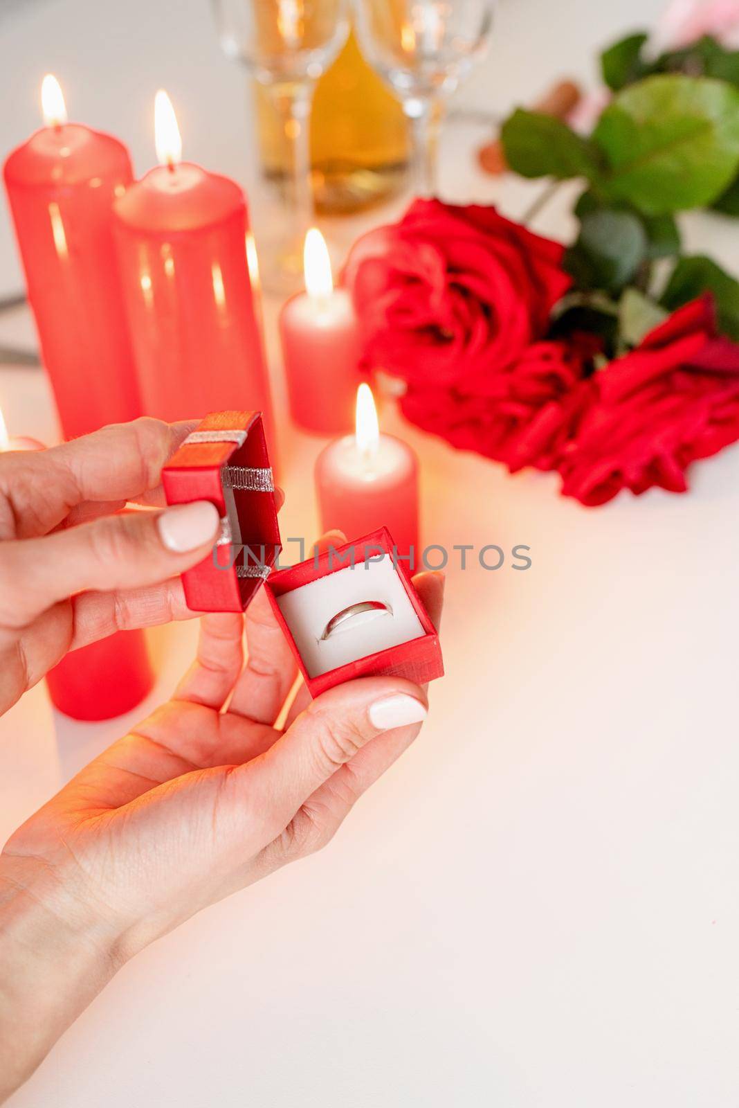 woman hand holding wedding ring in red box