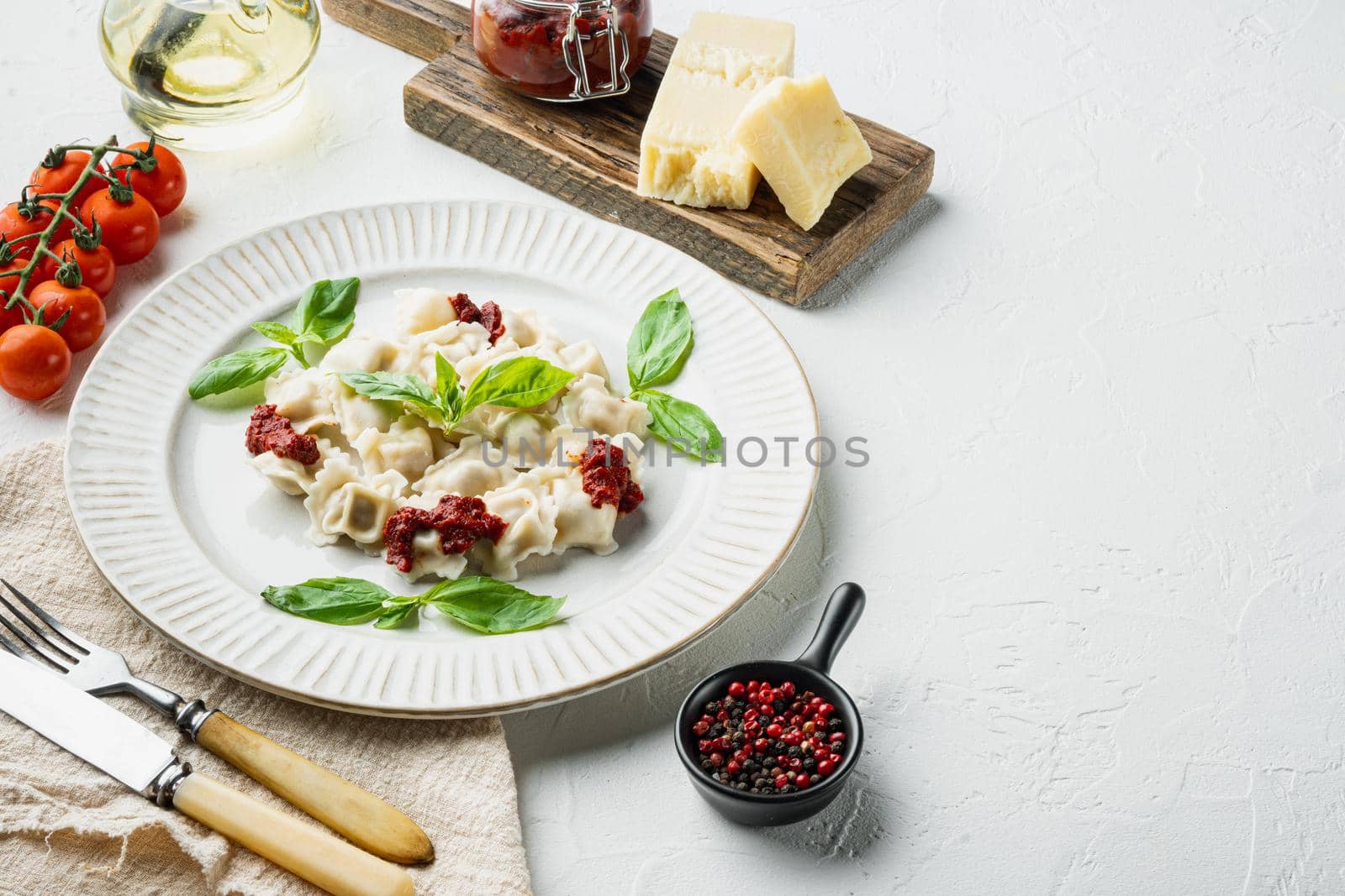 Ravioli pasta with mushroom cream sauce and cheese - Italian food style with basil parmesan and tomatoe on white plate, on white background , with copyspace and space for text by Ilianesolenyi