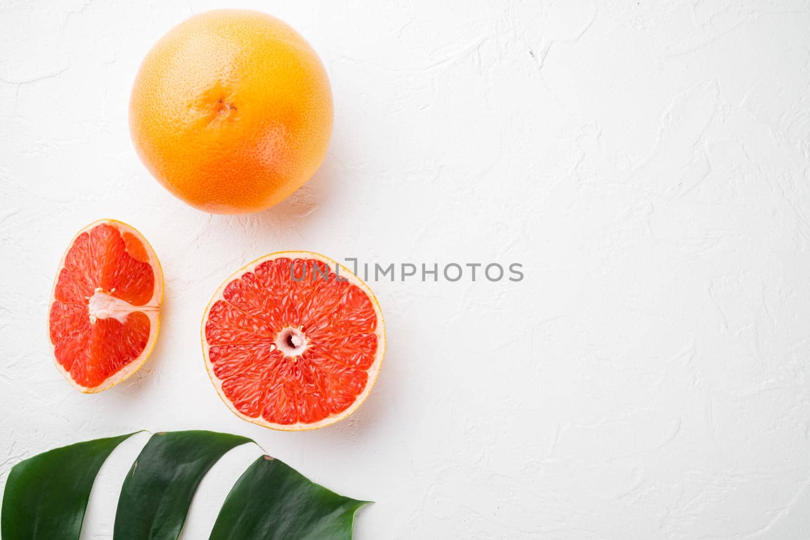 Juicy pink grapefruit cut set, on white stone table background, top view flat lay, with copy space for text