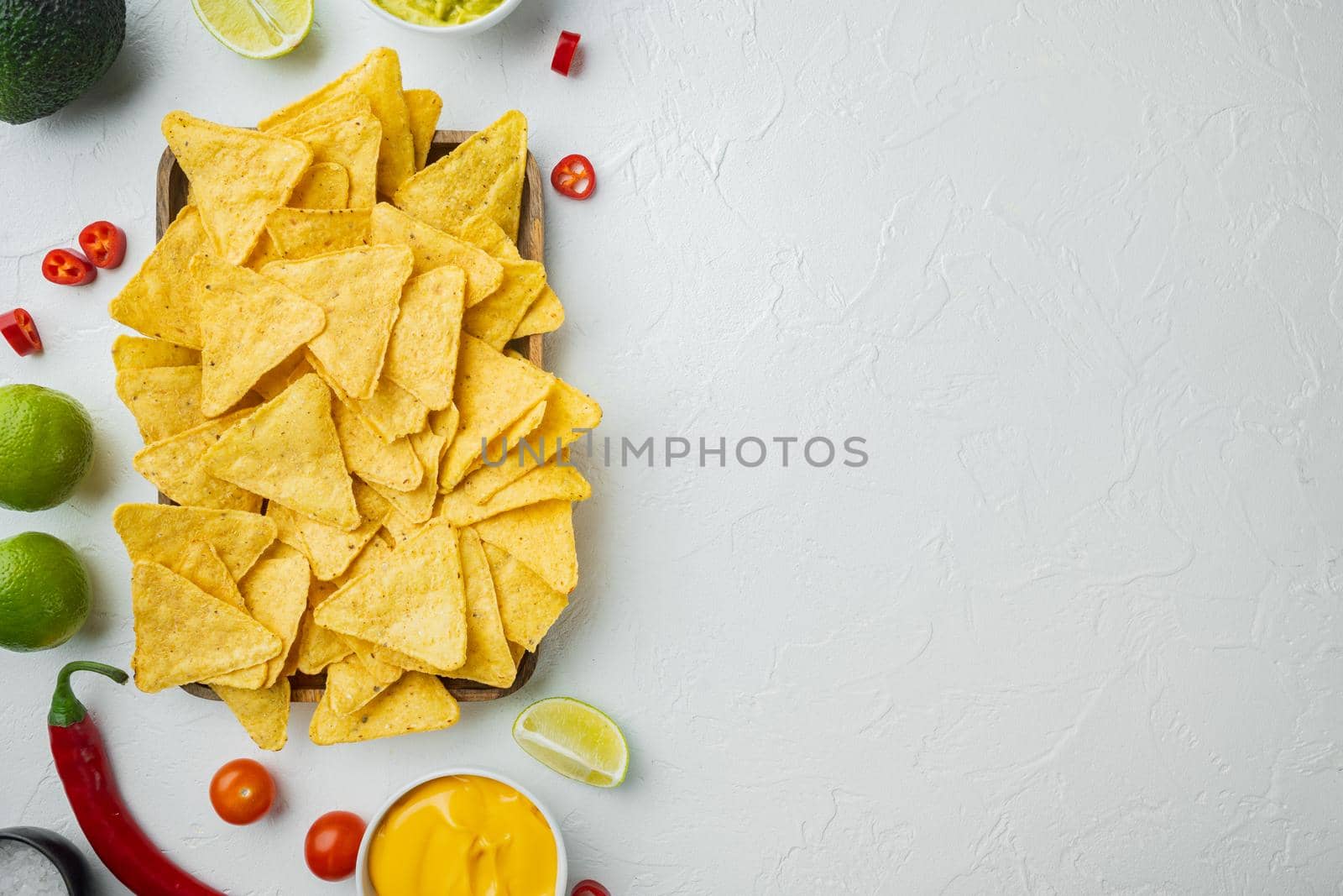 Nachos corn chips with traditional dip sauce , on white background, top view or flat lay with copy space for text by Ilianesolenyi