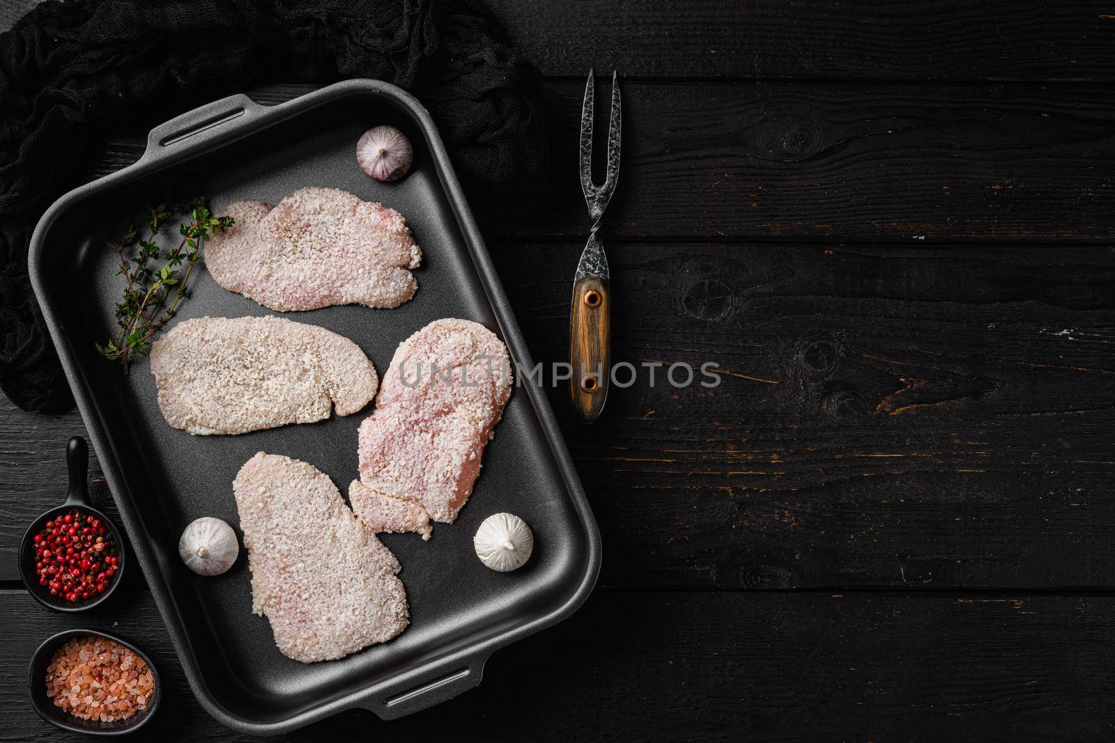Breaded chicken steak, on black wooden table background, top view flat lay, with copy space for text