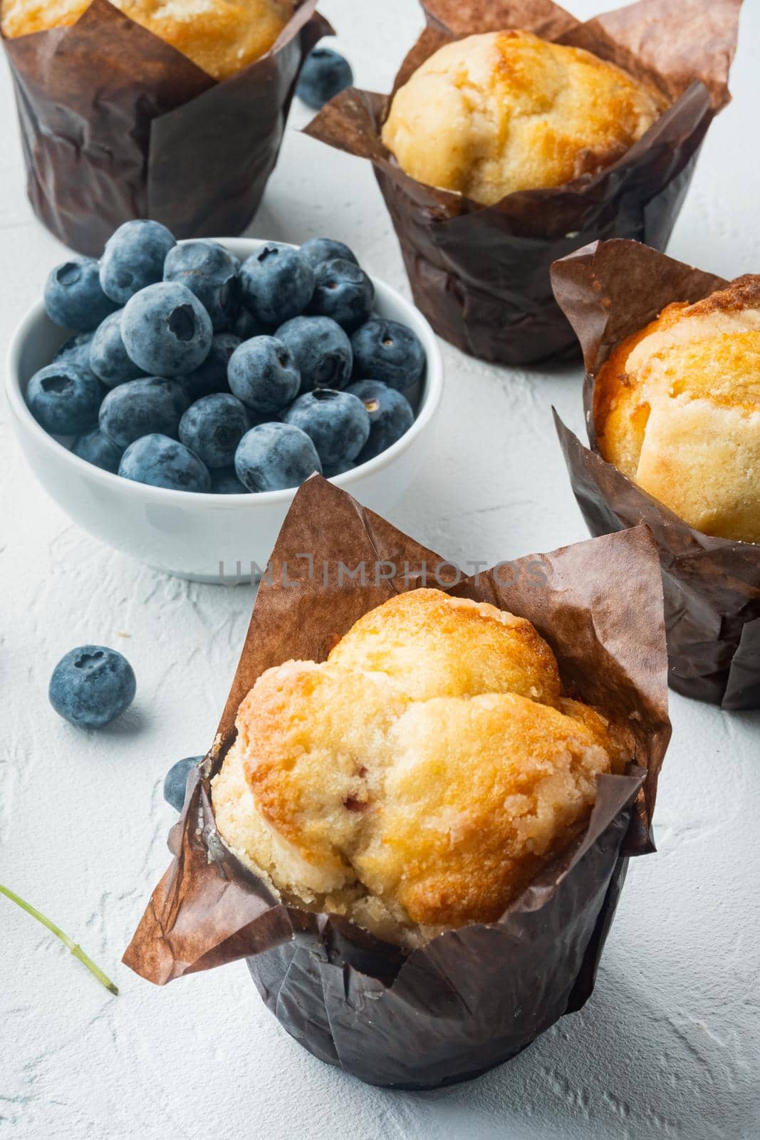 Muffins with blueberries, on white background