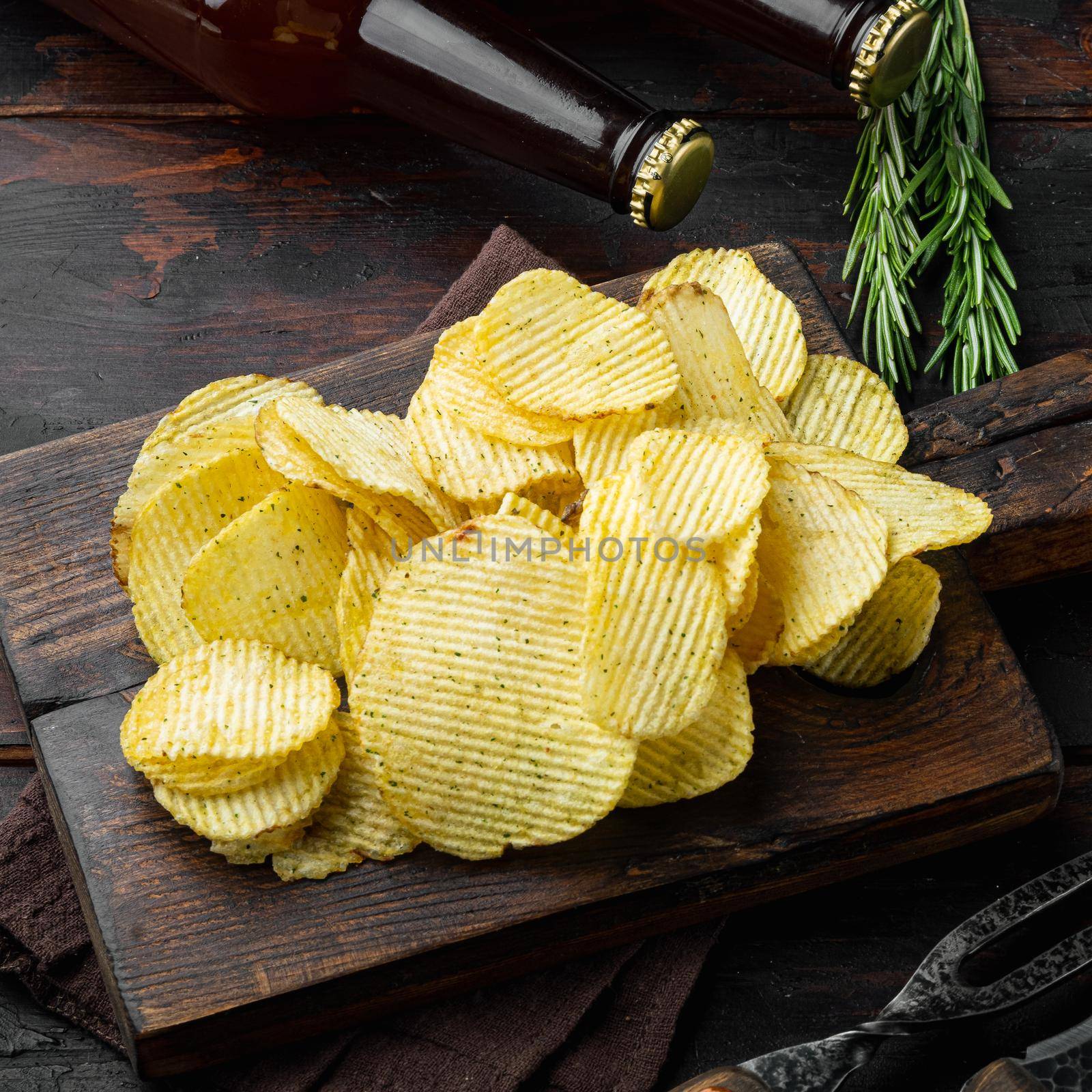 Potatoe chips, on old dark wooden table by Ilianesolenyi
