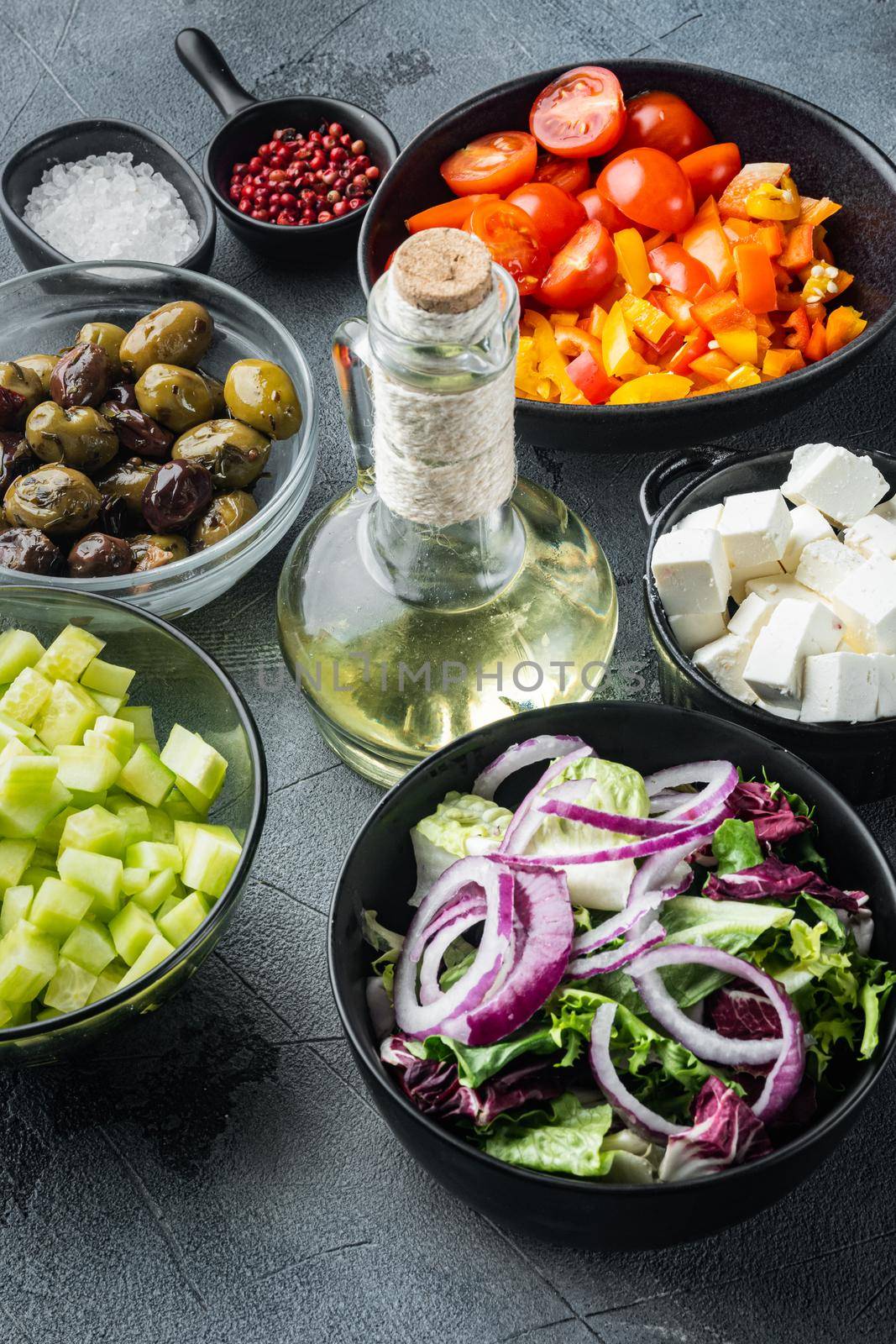 Ingredients for traditional greek salad, Tomatoes, onion, olives, feta cheese, on gray background