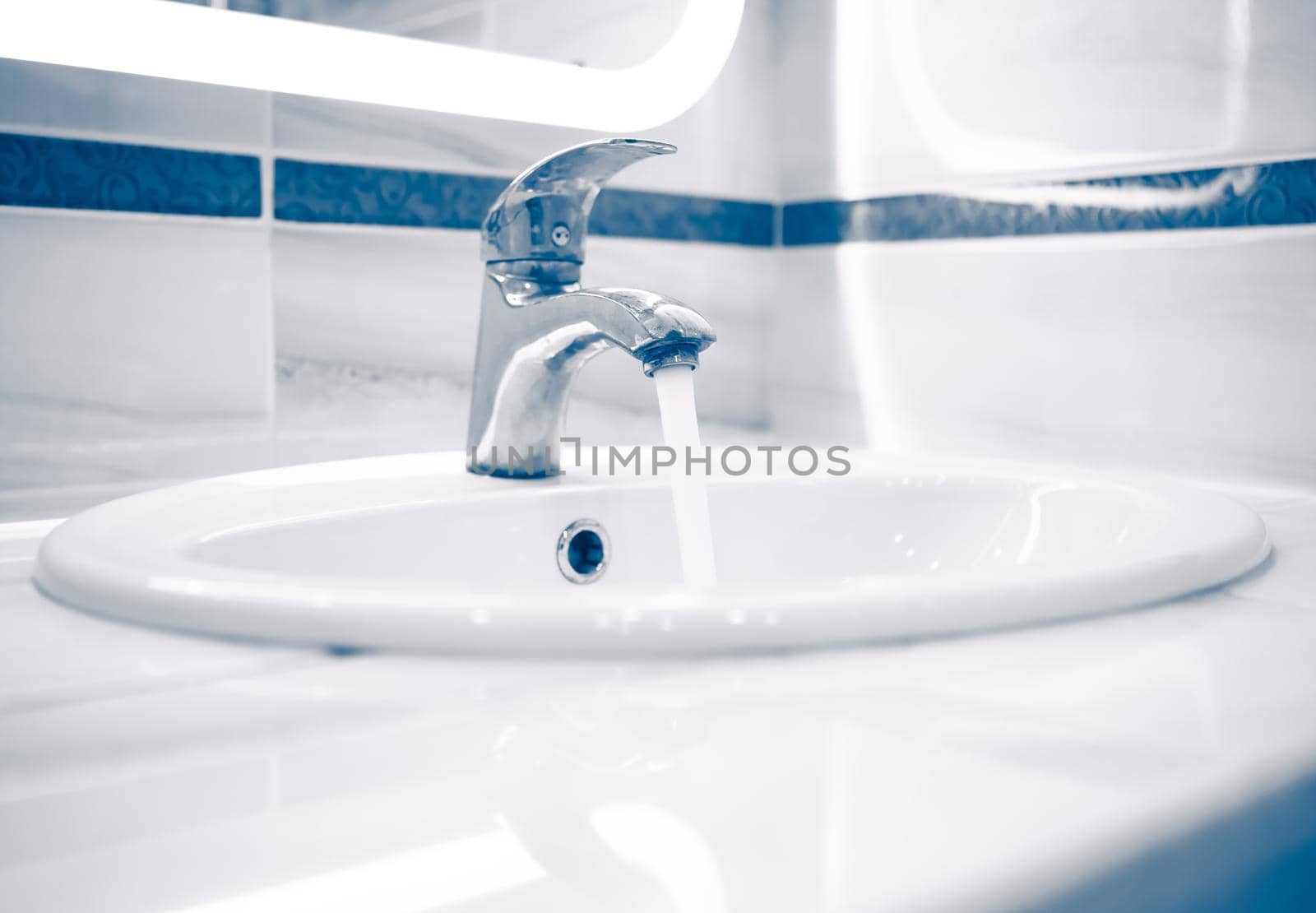 tap faucet with flowing water, blue tone