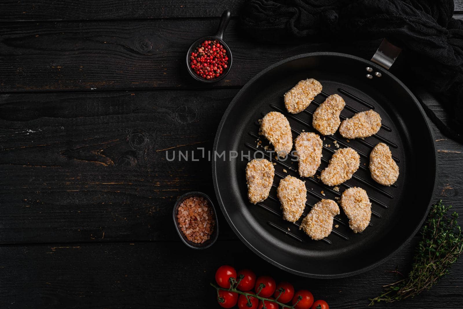 Raw chicken nuggets meat, on black wooden table background, top view flat lay, with copy space for text