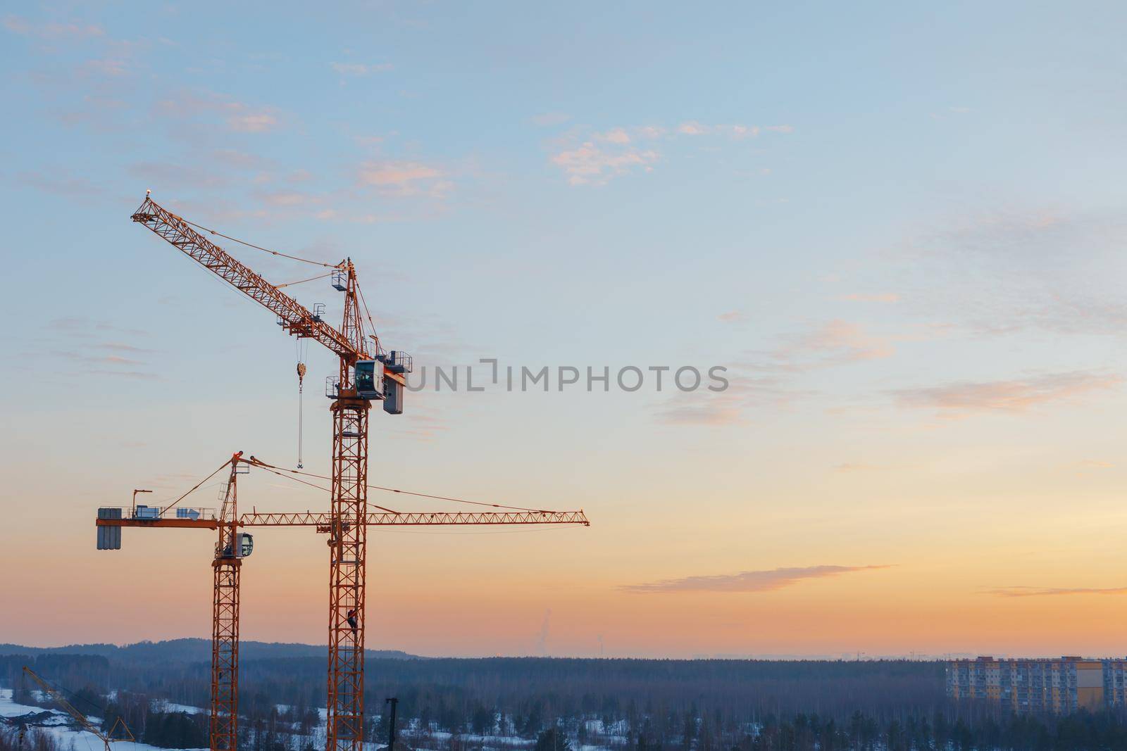 building cranes on the construction site at sunset background by nikkytok