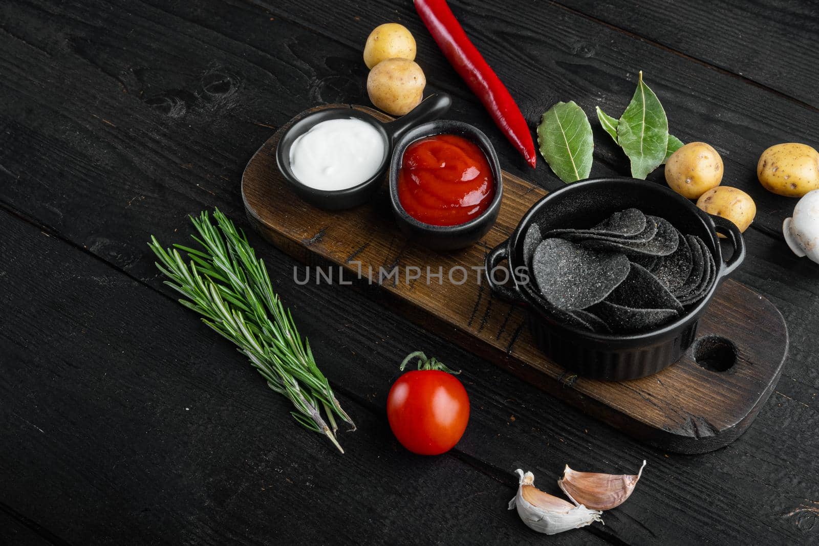 Cheese and chive potato crisp snack set, on black wooden background