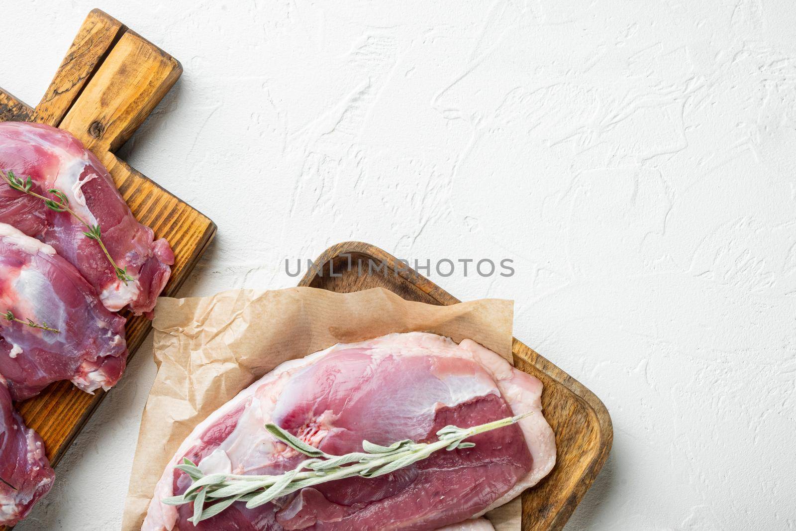 Free range Duck meat set, on wooden cutting board, on white stone background, top view flat lay, with copyspace and space for text