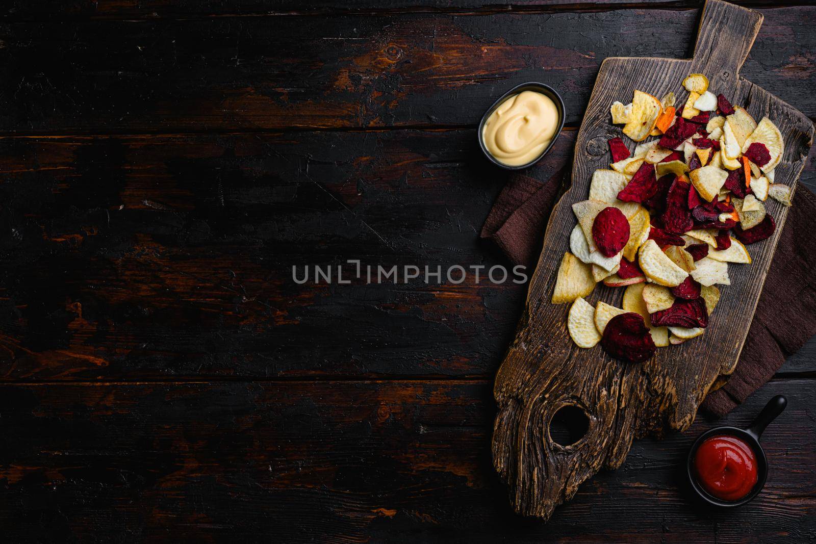 Beetroot carrot and turnip chips set, on black wooden table background, top view flat lay, with copy space for text