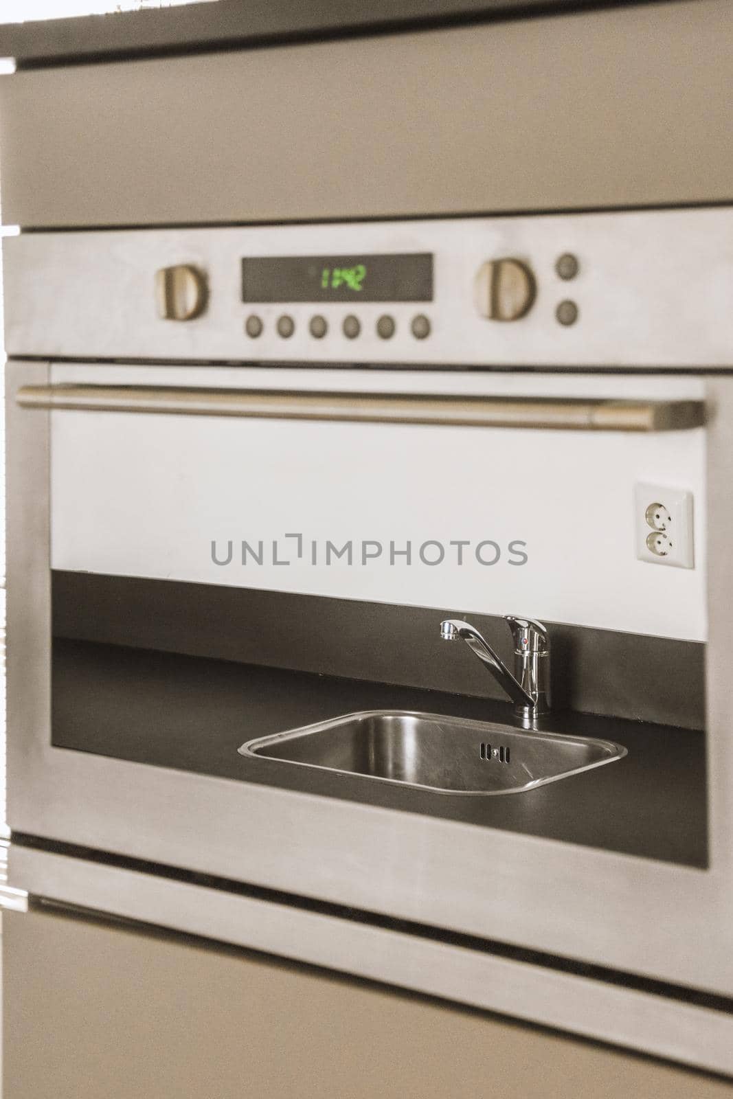 Silver colored cooker in front of the kitchen sink