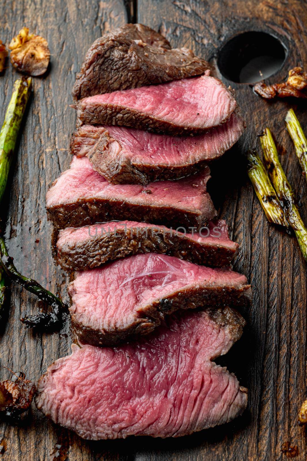 Grilled fillet mignon beef steak set, with onion and asparagus, on wooden serving board