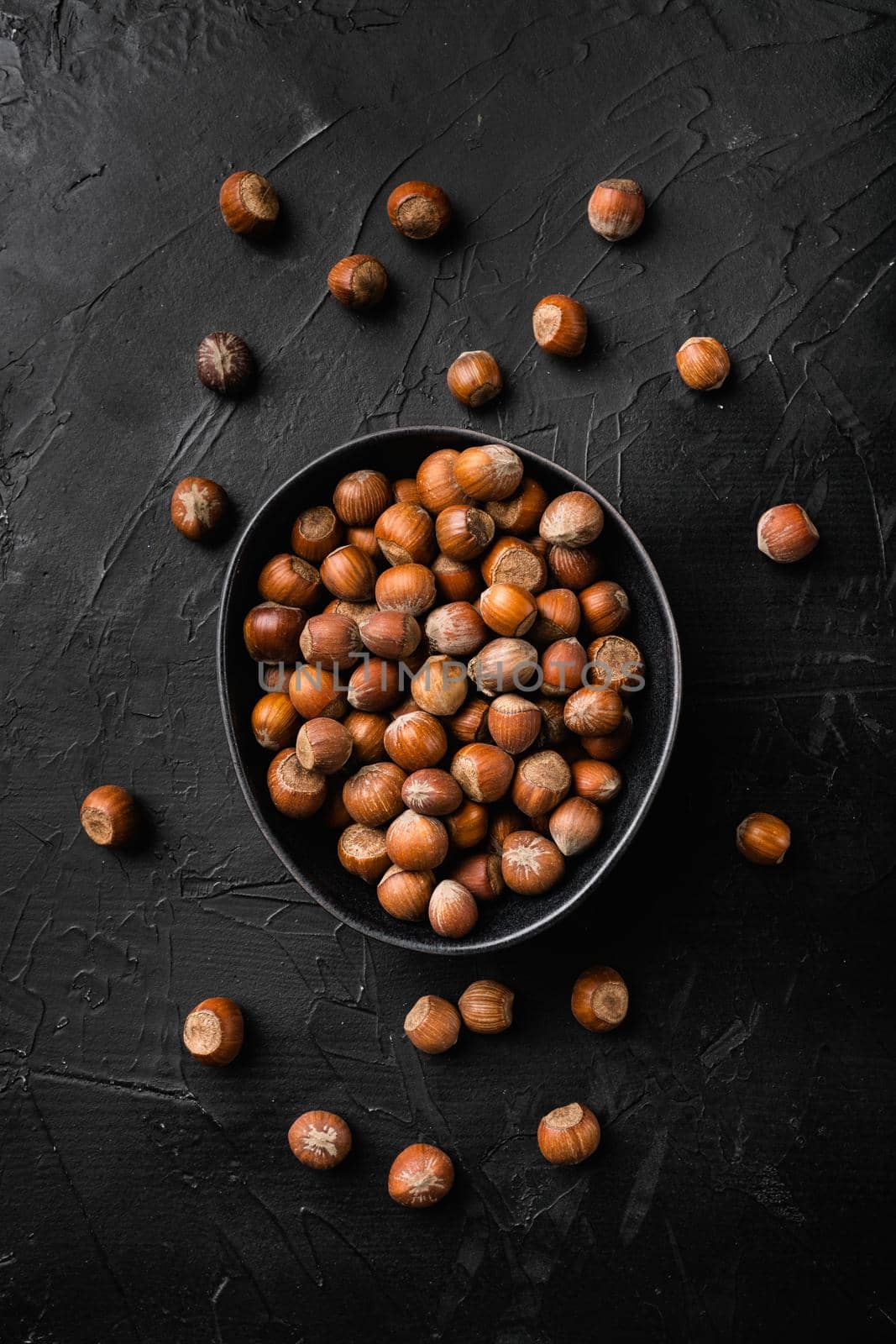 Hazelnut nut health organic brown filbert, on black dark stone table background, top view flat lay by Ilianesolenyi