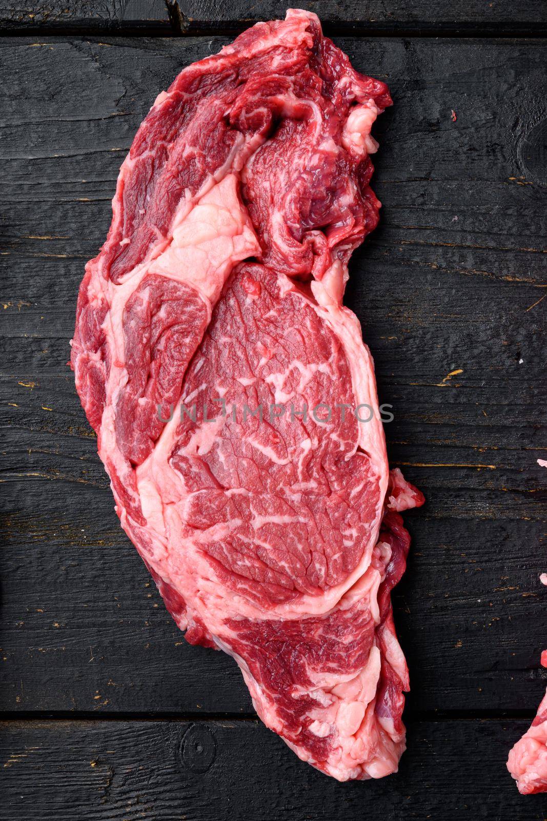 Rib eye steak of beef marbled meat or scotch fillet set, on black wooden table background, top view flat lay