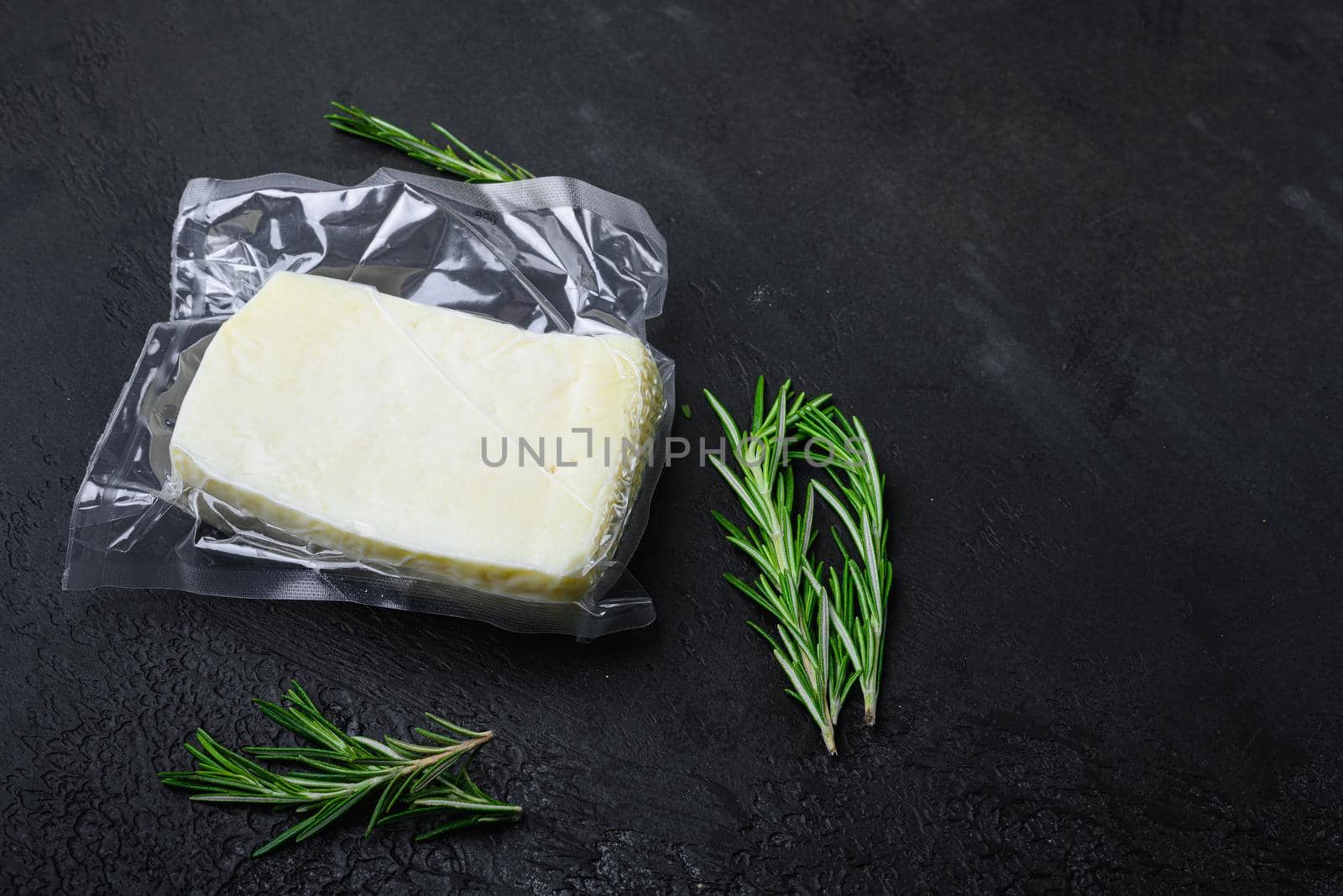Cyprus Halloumi cheese, on black dark stone table background, with copy space for text