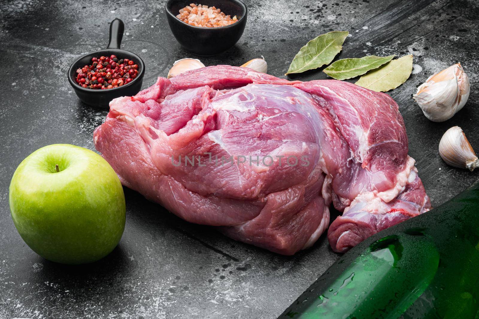 Pork roast ingredients, with apple dry cider, on black dark stone table background by Ilianesolenyi