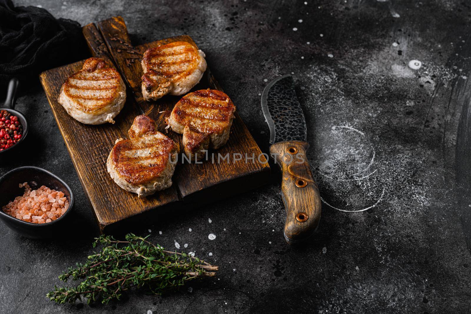 Grilled pork fillet meat set, on black dark stone table background, with copy space for text by Ilianesolenyi