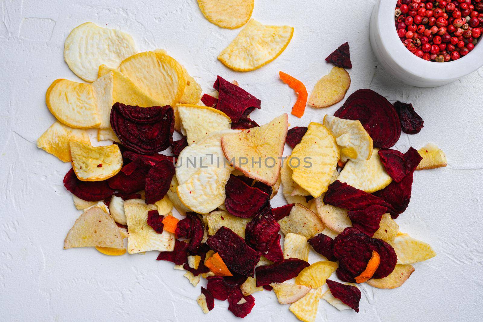 Beetroot carrot and turnip chips, on white stone table background, top view flat lay by Ilianesolenyi