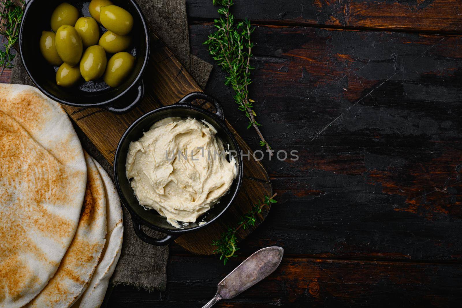 Hummus traditional Jewish creamy lunch, on old dark wooden table background, top view flat lay, with copy space for text