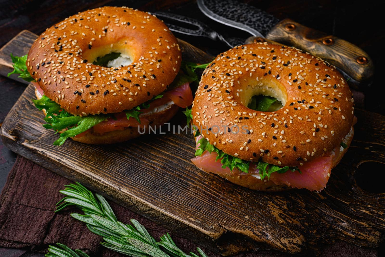 Fresh Smoked Salmon And Cream Cheese Bagel, on old dark wooden table background by Ilianesolenyi