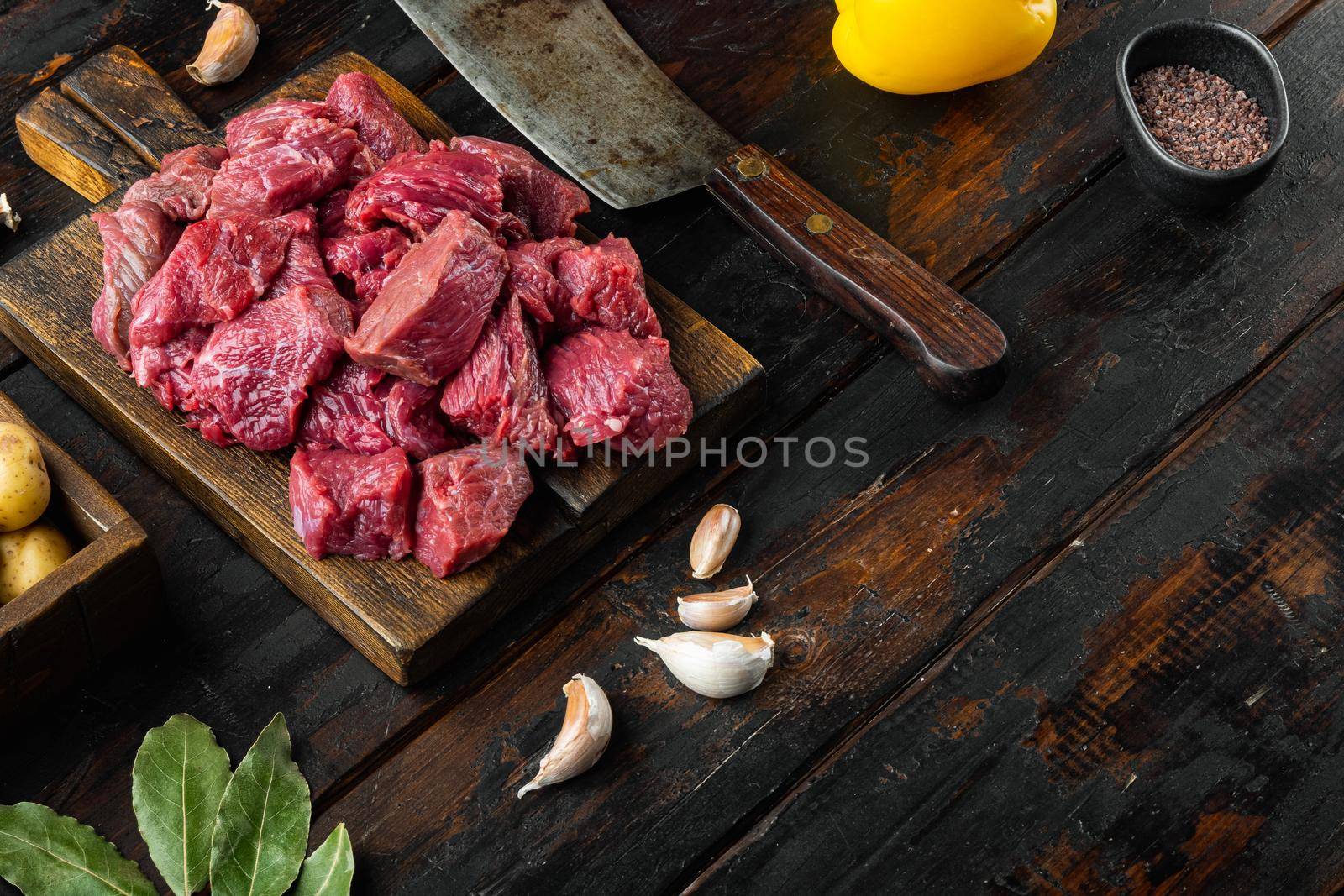 Beef chuck stew ingredients set, on old dark wooden table, with copy space for text