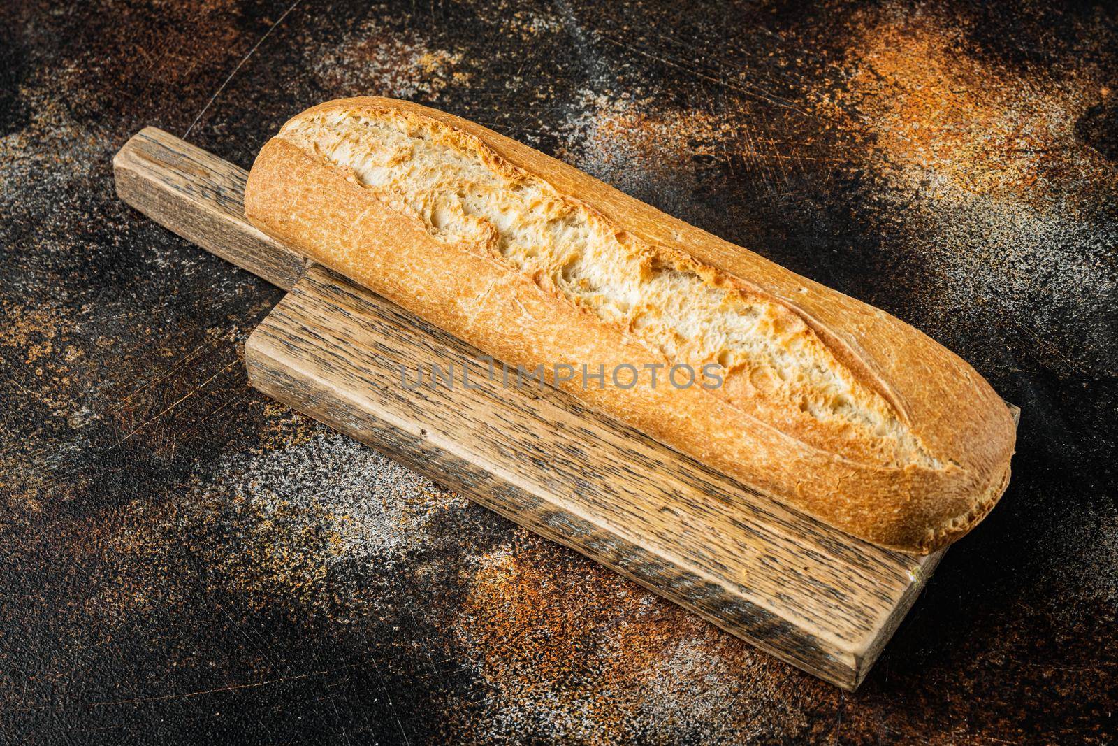 Freshly baked baguette bread, on old dark rustic background