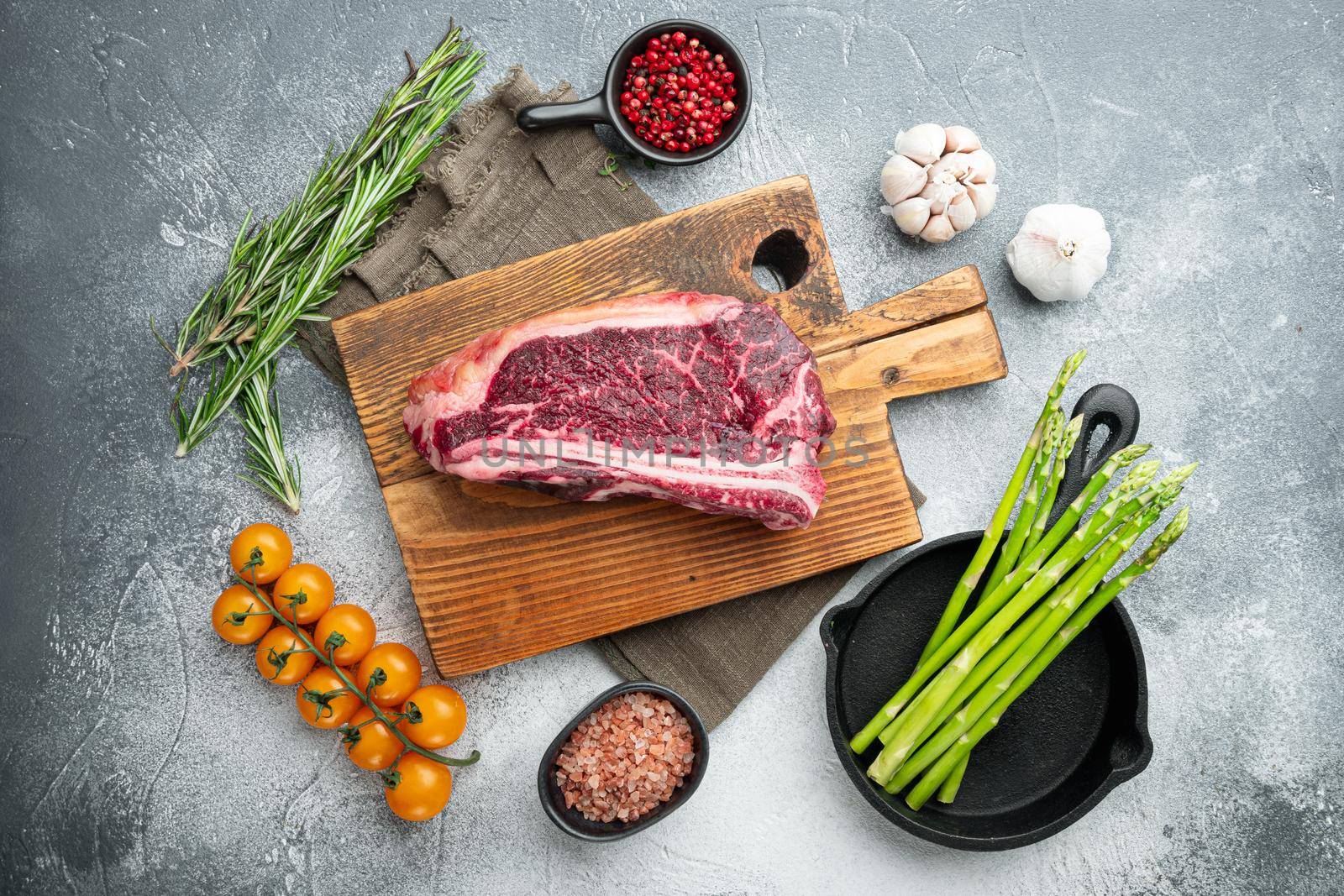 Raw fresh marbled meat Black Angus set, Club steak cut, on wooden cutting board, on gray stone background, top view flat lay