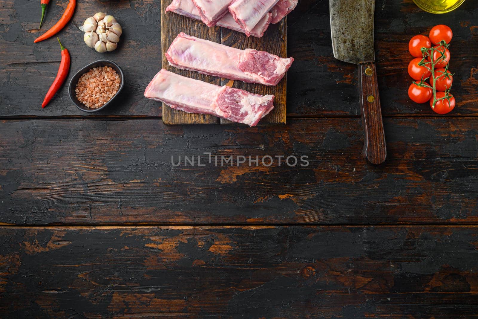Pork rib with ingredients set , with old butcher cleaver knife, on old dark wooden table, top view flat lay, with copy space for text