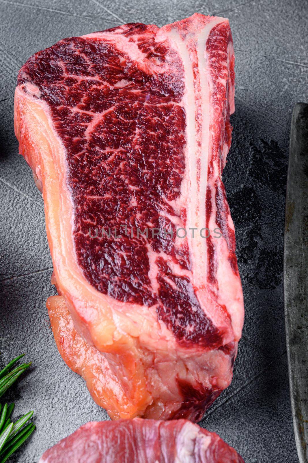 Club steak raw marbled beef meat, on gray stone background by Ilianesolenyi