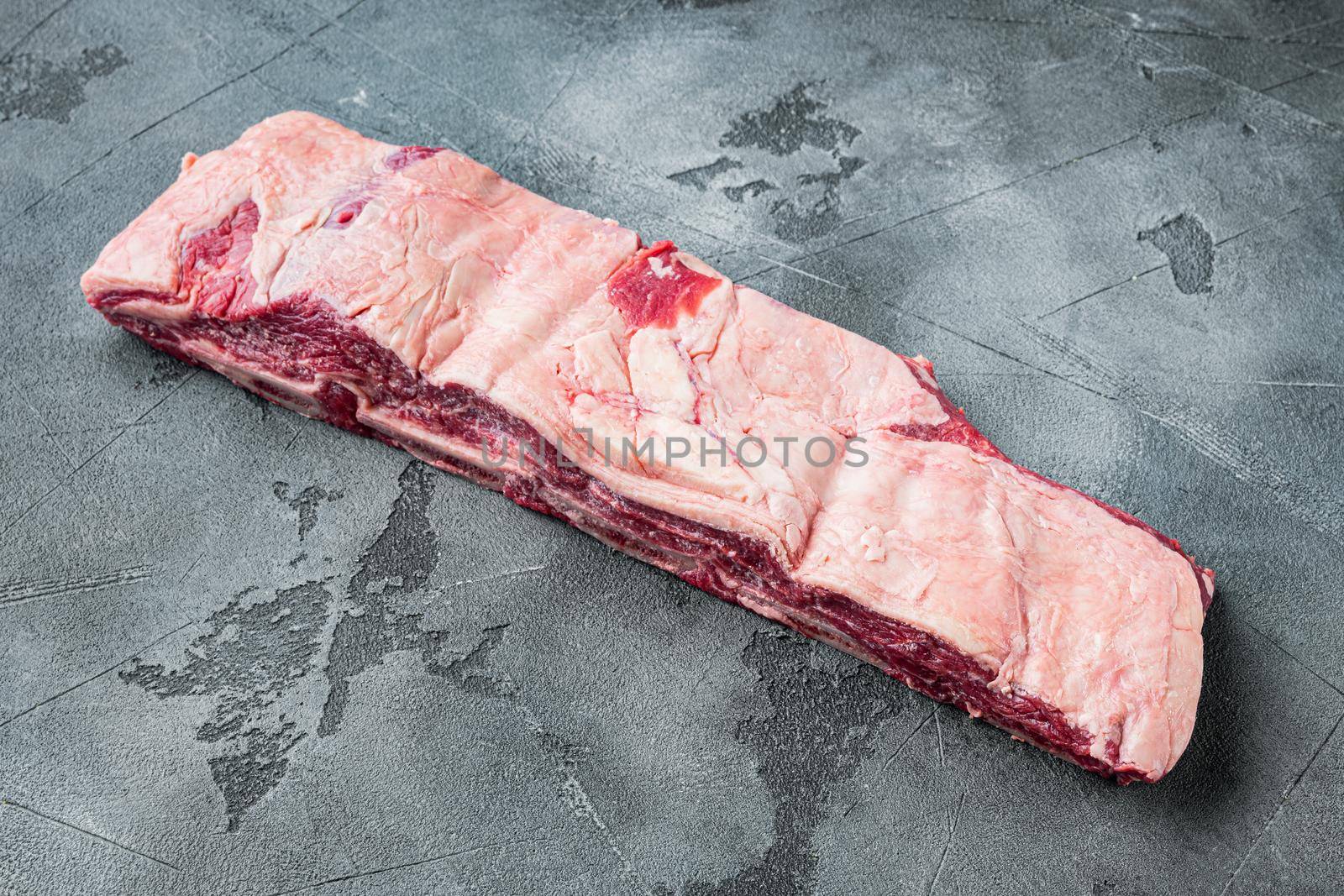 Raw meat ribs, on gray stone background, with copy space for text by Ilianesolenyi