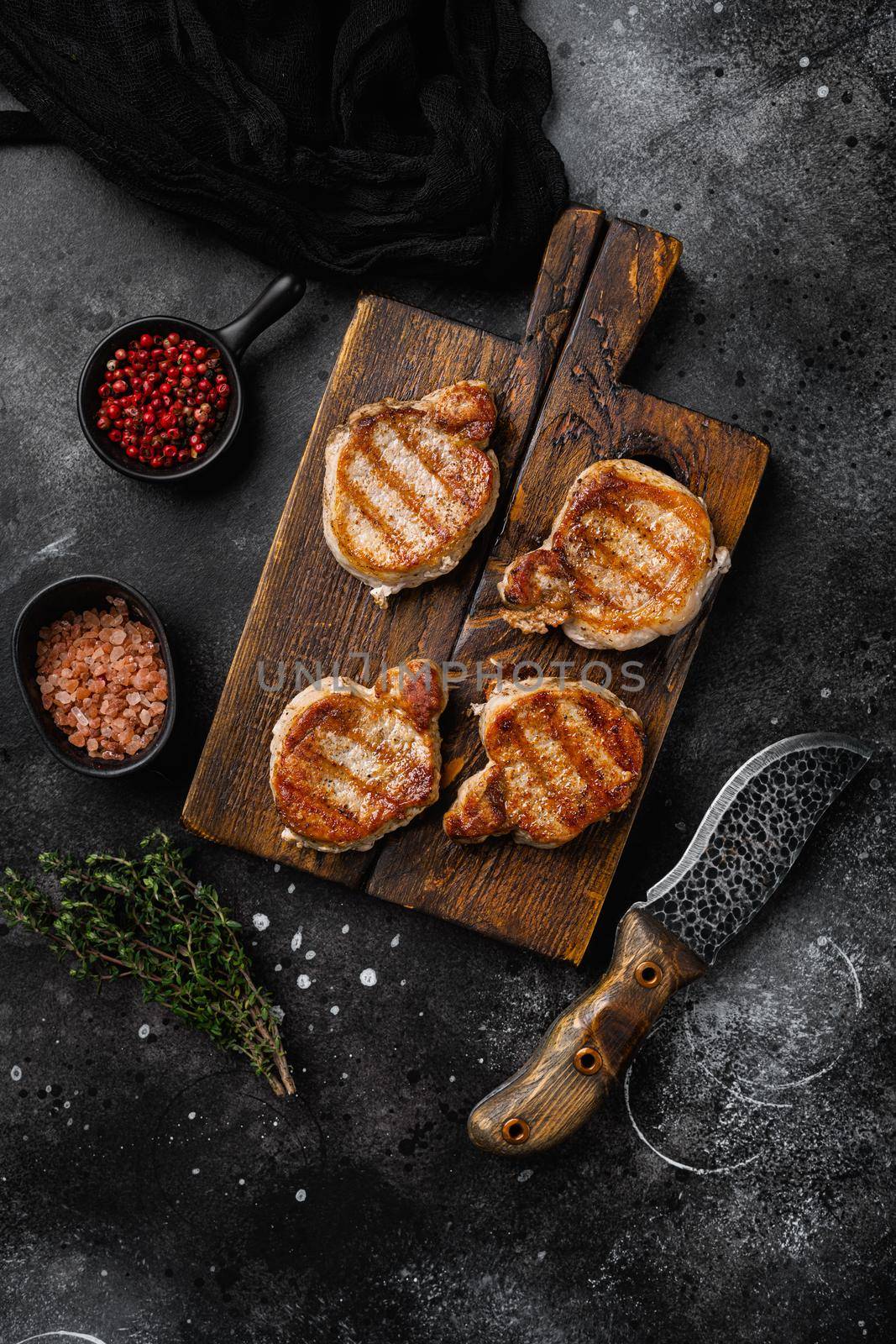 Grilled pork fillet meat, on black dark stone table background, top view flat lay, with copy space for text