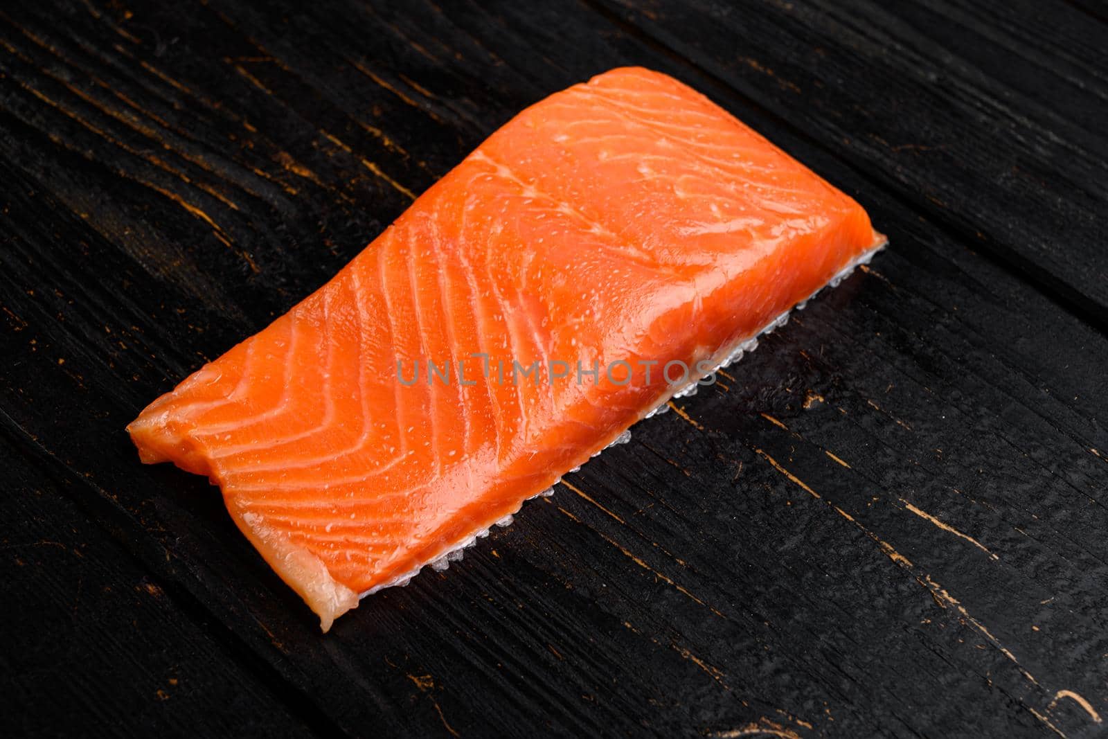 Fresh raw salmon fillet set, on black wooden table background, with copy space for text