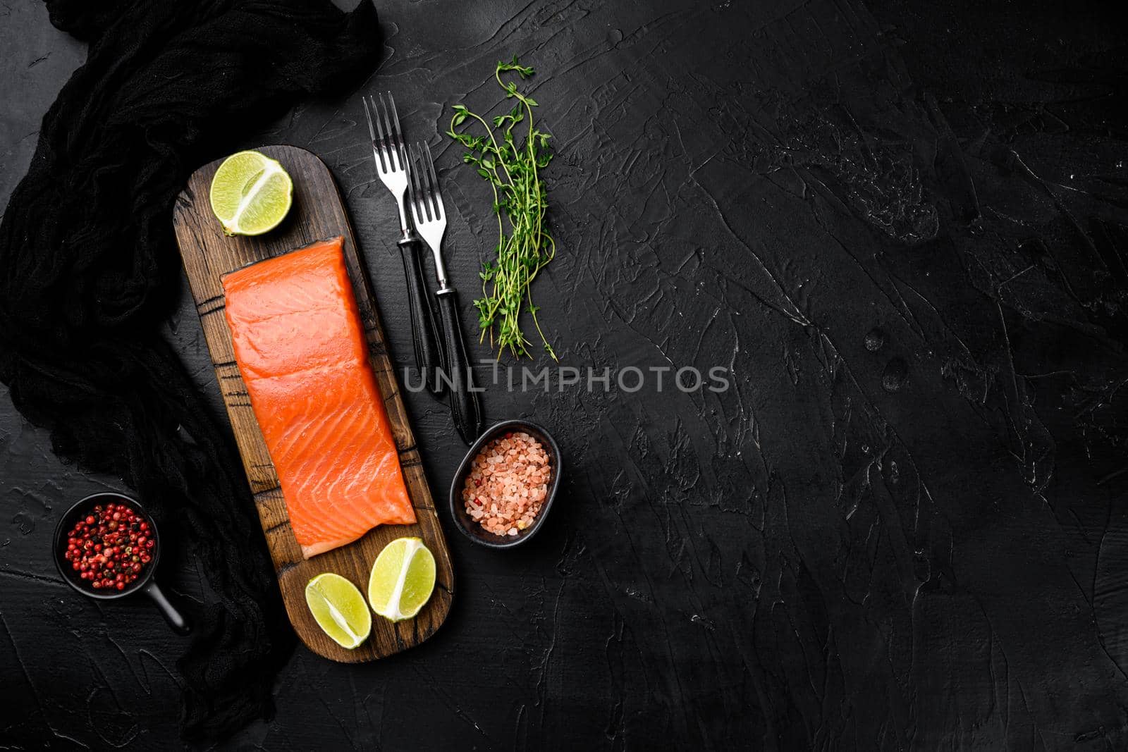 Salmon fillet fish set, with herbs, on black dark stone table background, top view flat lay, with copy space for text