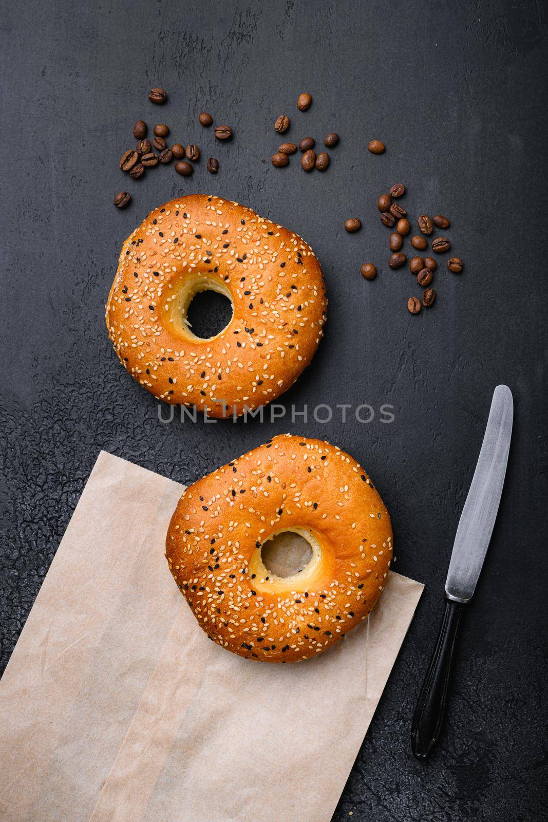 Fresh Sesame Bagel set, on black dark stone table background by Ilianesolenyi